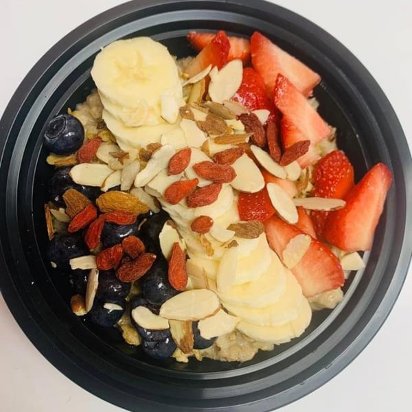 A Coco Loco smoothie bowl with bananas, blueberries, strawberries, goji berries, and sliced almonds.