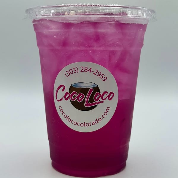 A vibrant pink Coco Loco smoothie with ice in a clear plastic cup with the brand's logo.