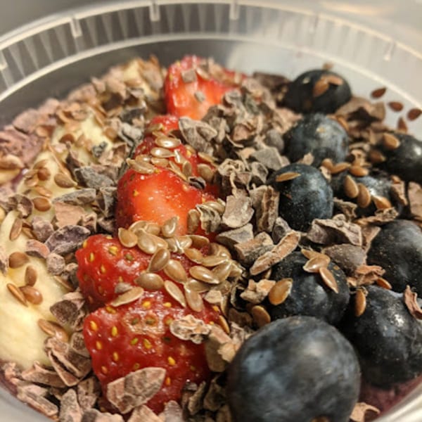 Coco Loco smoothie bowl with strawberries, blueberries, banana, cacao nibs, and flax seeds.